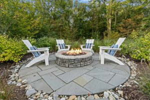 In-ground Gunite (Concrete) pool inground gunite (concrete) swimming pool with a tanning ledge/sun shelf and full-perimeter stone coping and patio.